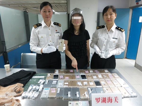 En kvinne ble tatt på grensen mellom Hongkong og Kina da hun forsøkte å smugle over 100 iPhoner.