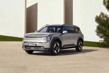 Kia EV9 Air parkert foran en moderne bygning. Rimeligere utgave av el-SUV-en med 512 km rekkevidde, 384 hk, hurtiglading og syv seter.