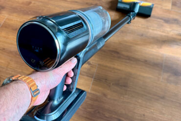 Hånd som holder Dreame Z30 Ultra håndholdt støvsuger over gulv, en kraftig konkurrent til Dyson med 330 AW sugekraft og fleksibelt design.