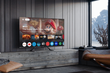 Sharp 50GR8465E-TV som viser Google TV-grensesnittet med strømmetjenester på skjermen i en moderne stue.