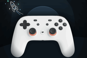 Hvit Google Stadia-kontroller vist mot mørk bakgrunn, med analoge stikker, styreknapper og D-pad tydelig synlig.