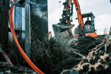 Graving i bakken for legging av fiberkabler til bredbåndsnett.