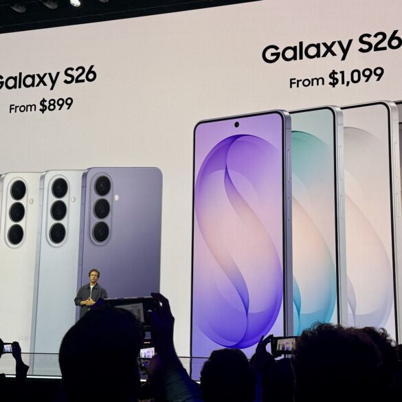 Scene fra Samsung-presentasjon som viser Galaxy S26-serien på storskjerm med ulike fargevarianter og startpriser under lanseringsevent.