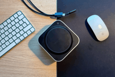 Mac mini sett ovenfra på skrivebord ved siden av tastatur og mus.