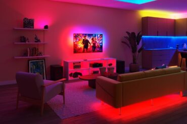 Philips Smart Lighting viser frem WiFi-basert smartbelysning med synkroniserte LED-lys rundt TV, møbler og kjøkken i et moderne stueoppsett.