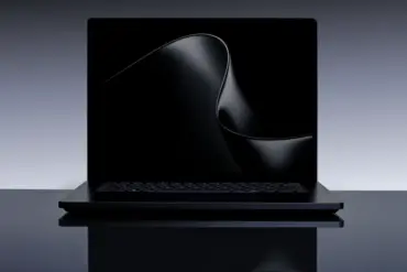 En sort bærbar datamaskin av typen Surface Laptop Ultra vist forfra på en mørk, reflekterende overflate, med en minimalistisk, bølgeformet digital bakgrunn på skjermen.
