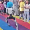 Unitree G1-robot med blå klovneparykk opptrer foran publikum på et turiststed i Kina kort tid før den sparket et barn under en demonstrasjon.