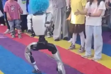 Unitree G1-robot med blå klovneparykk opptrer foran publikum på et turiststed i Kina kort tid før den sparket et barn under en demonstrasjon.