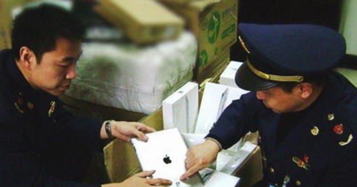 Dette bildet fra februar i år viser hvordan kinesisk politi fjerner iPad fra butikkhyllene.