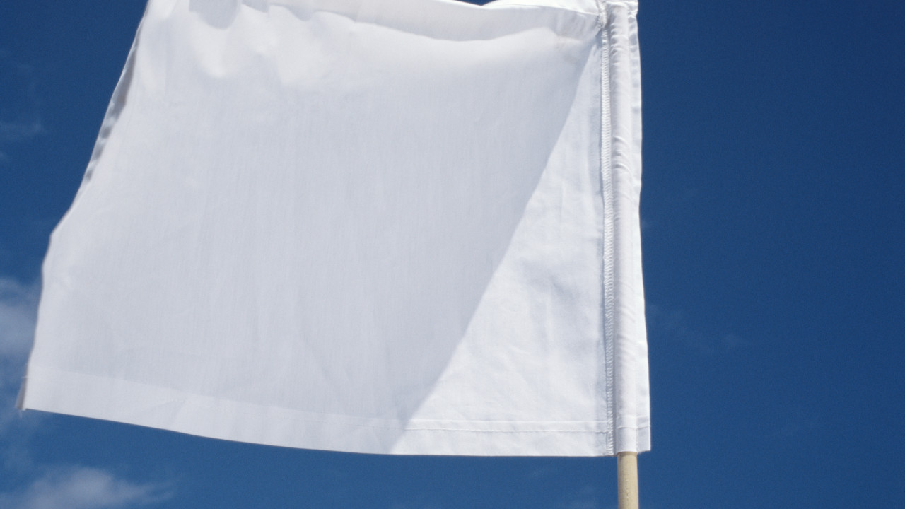 Close up of a white flag against blue sky